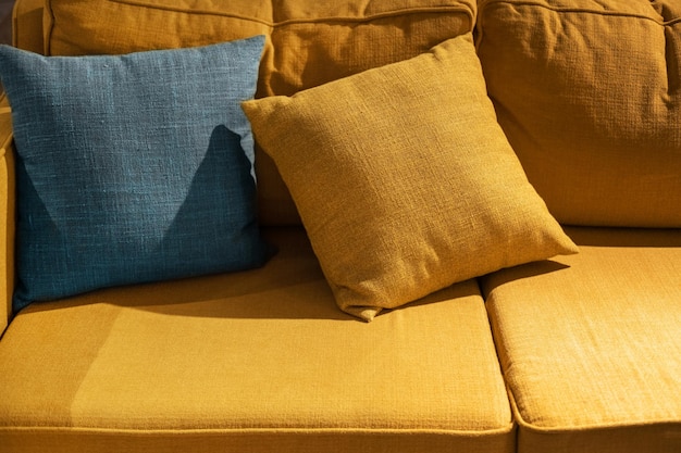 Multicolored pillow on yellow sofa background