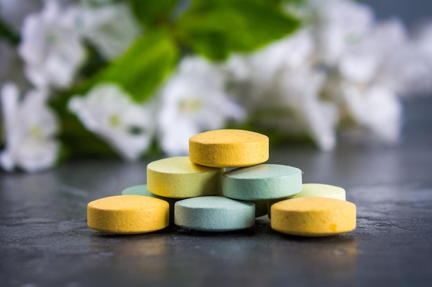 Multicolored pills closeup on a gray concrete background Selective focus