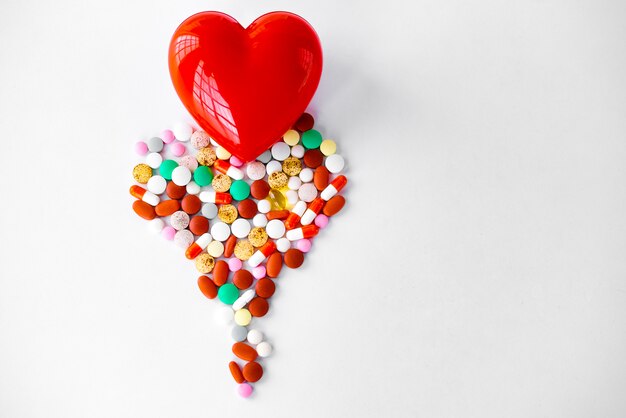 Foto pillole multicolori sul tavolo a forma di cuore su uno sfondo bianco