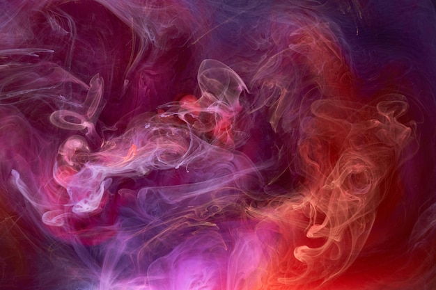 色とりどりのピンクの煙の抽象的な背景のアクリル絵の具の水中爆発