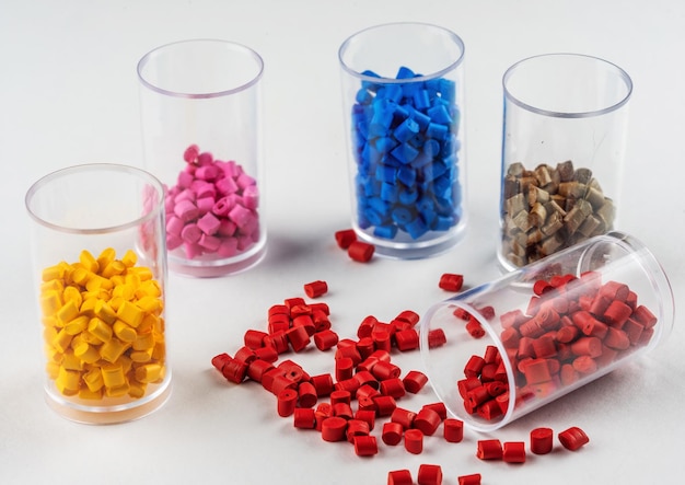 Photo multicolored plastic dye in granules in test tubes isolated on a white background