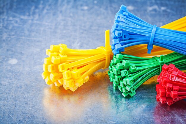 Multicolored plastic zip cable ties on metallic background construction concept