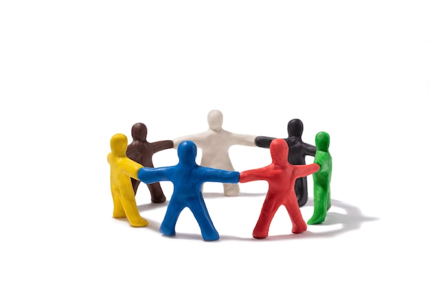 Multicolored plasticine people standing in a circle isolated on white Community concept