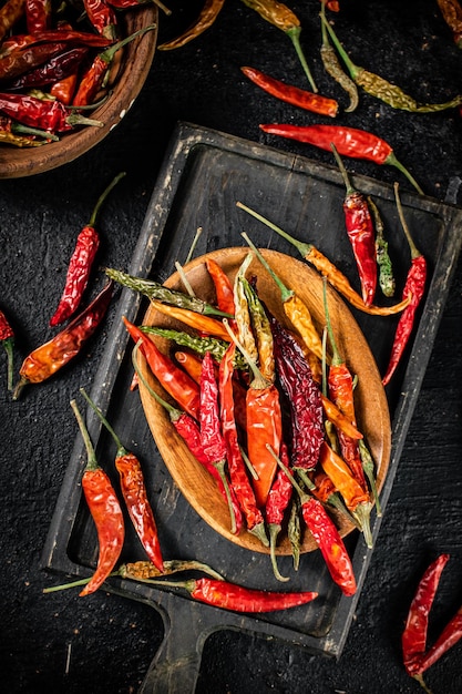 Photo multicolored pods of dried chili peppers on a cutting board