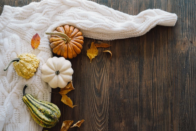 Разноцветные тыквы и сухие осенние листья на деревянном фоне Плоский вид сверху на осень Осень Концепция Дня Благодарения Осенний фон