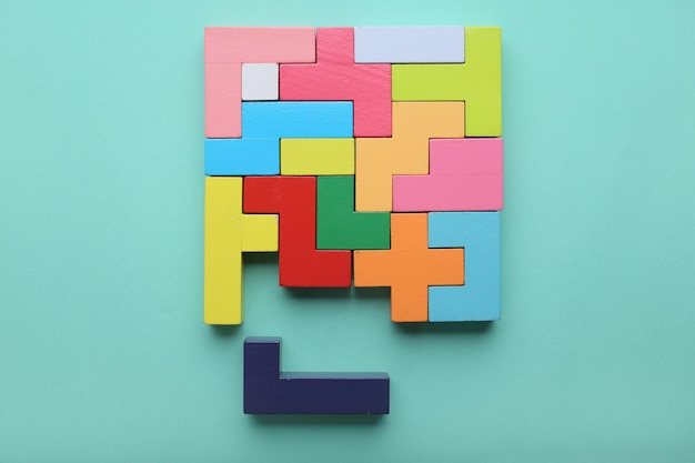 Puzzle multicolore a mano e cubi su uno sfondo di menta