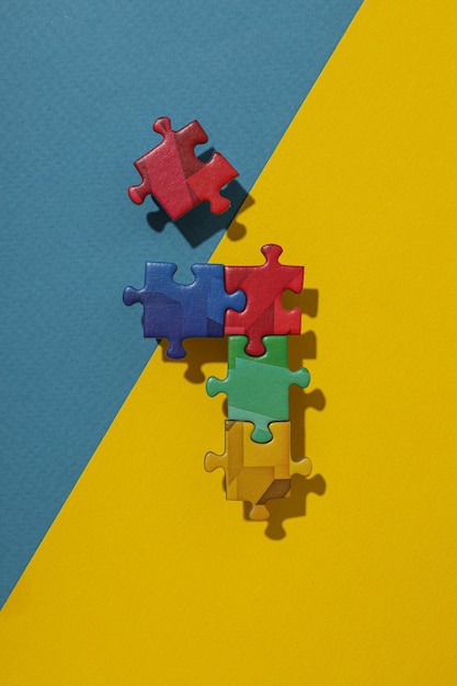 Multicolored puzzle pieces on a blueyellow background