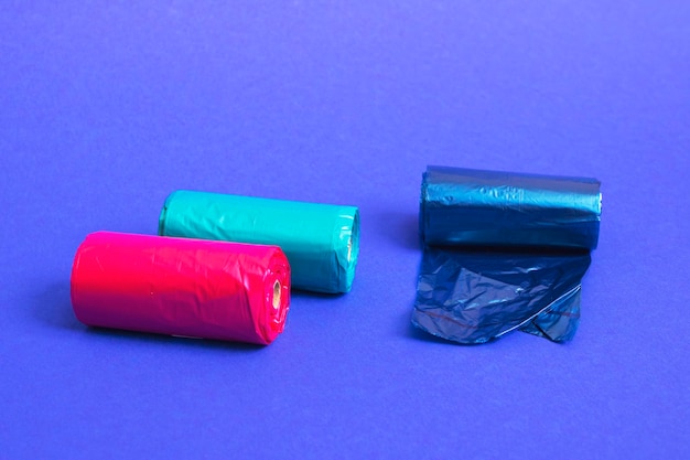 Multicolored rolls of plastic bags on blue background