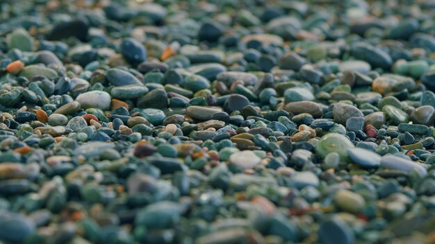 Photo multicolored sea pebbles in the oncoming waves pebble stones on sea shore