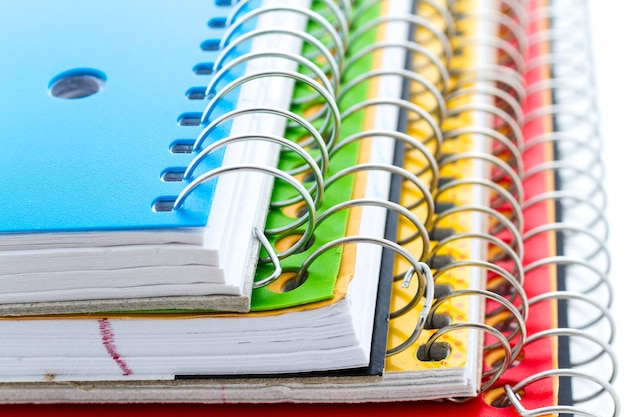 Photo multicolored spiral notebooks on a white background.