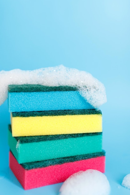 Multicolored sponges for cleaning on a blue background space
for text