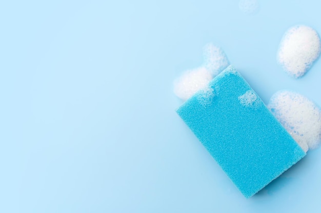 Multicolored sponges for cleaning on a blue background Space for text