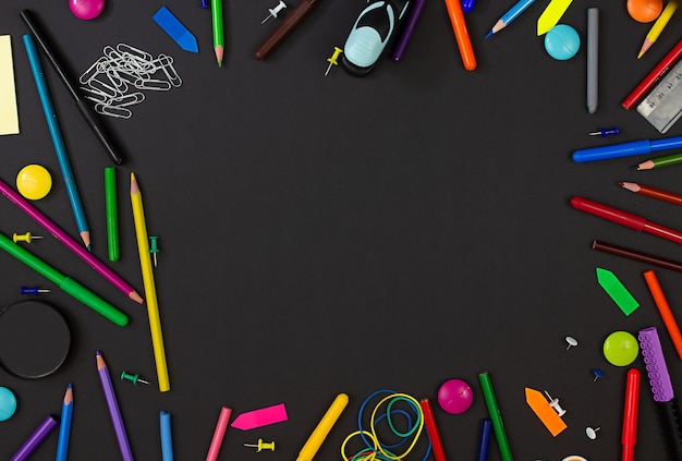 Multicolored stationery on a black background Copy space Back to school concept