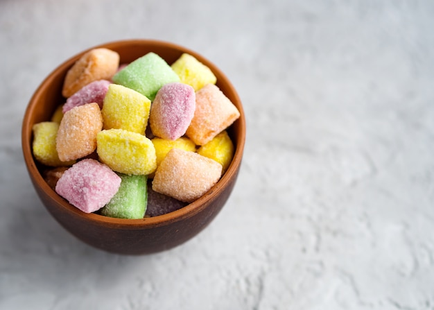 Multicolored sweets (candy pads) in a clay cup