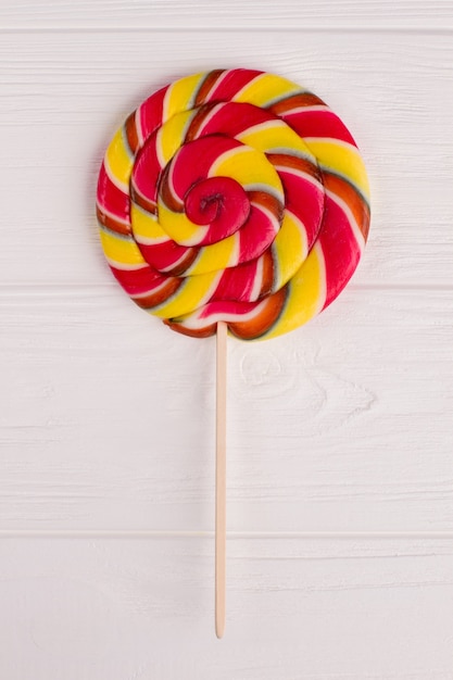Multicolored swirl lollipop on stick. Colorful swirl lollypop on wooden stick. Top view