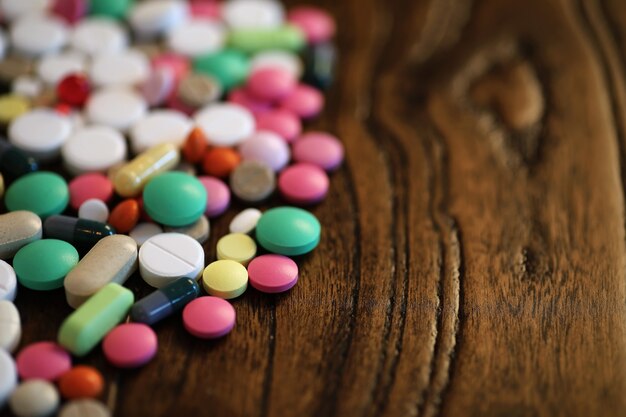 Multicolored tablets of different shapes and sizes on the wooden floor