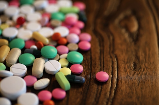 Multicolored tablets of different shapes and sizes on the wooden floor