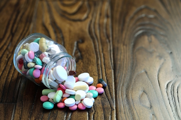 Multicolored tablets of different shapes and sizes on the wooden floor