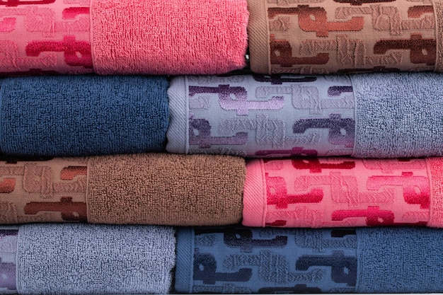 multicolored terry towels, rolled up and stacked on the table