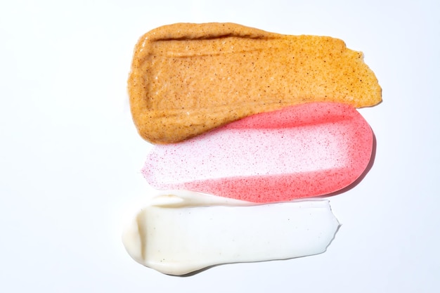 Multicolored texture of cream scrub with serum oil and\
hyaluronic acid on a white background concept of cosmetics smear of\
skincare cosmetics product