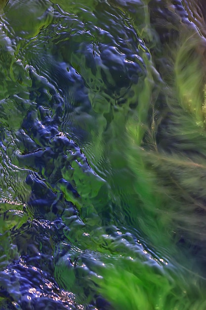 Struttura multicolore superficie del flusso d'acqua, acqua limpida, pietre colorate sul fondo del fiume