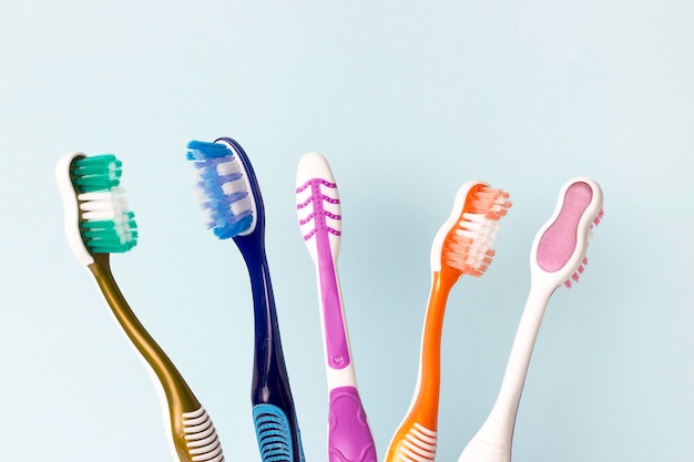 Multicolored toothbrushes on a blue background copy space