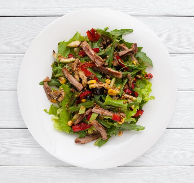 Multicolored vegetable salad with grilled meat