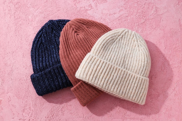 Multicolored warm hats on a pink background