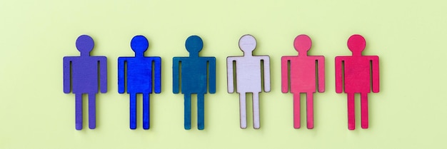 Multicolored wooden figurines of man on yellow background