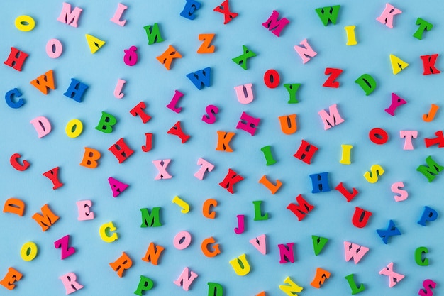 Multicolored wooden letters on blue background. top view