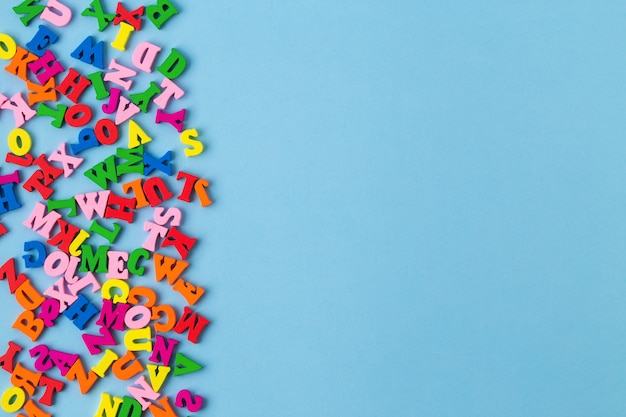 Multicolored wooden letters on blue background. top view.