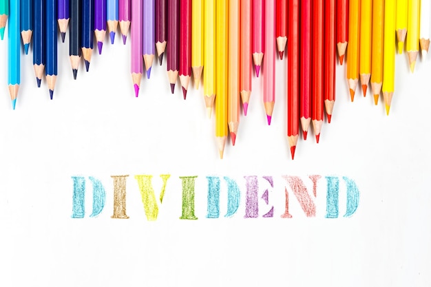 Multicolored wooden sticks Wooden colouring pencils and dividend on white background