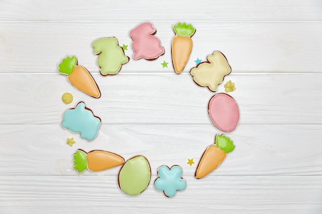 Multicoloured cookies shaped as rabbits carrots eggs and flowers