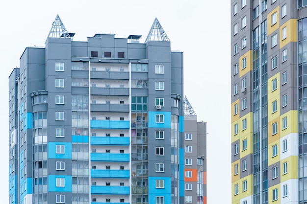 Multicoloured highrise residential buildings in affluent areas Multiapartment multistorey building with a multicolored facade against a blue sky background Modern design Buying a home