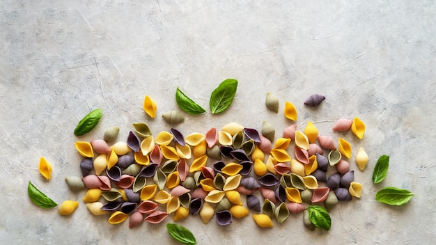 Multicoloured Italian pasta conchiglie or seashells. Flatly with copy space.