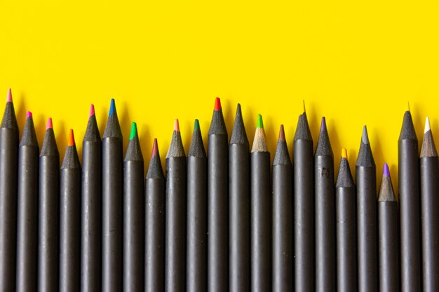 multicoloured pencils on yellow background.