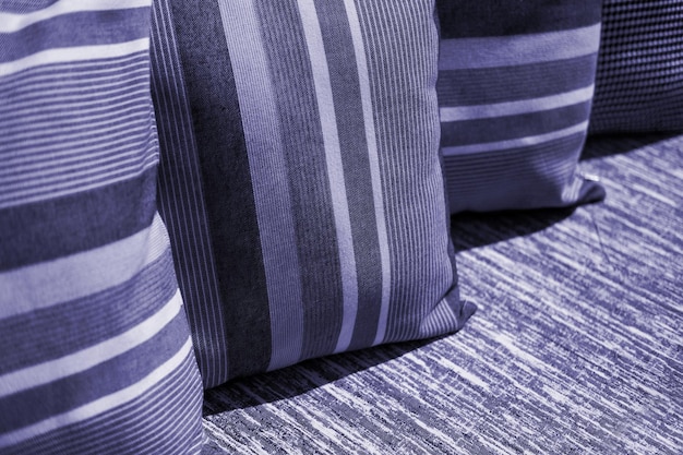 Photo multicoloured pillow on sofa background new 2022 trending pantone 173938 very peri color