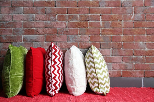 Photo multicoloured pillows on a brick wall background