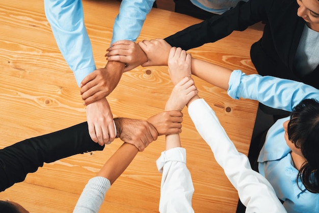 Multicultural business people holding hand together in circle unity teamwork in office business workplace diverse ethnic office worker engaged in team building habiliment