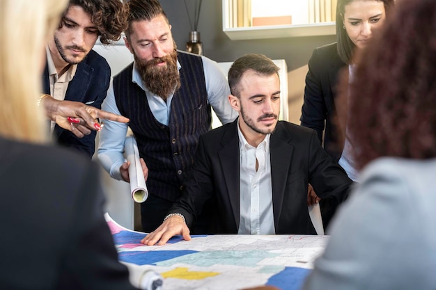 Multicultural business people working together on sustainable innovation project Architect office colleagues designing new land defense elements Focus on man's face in center