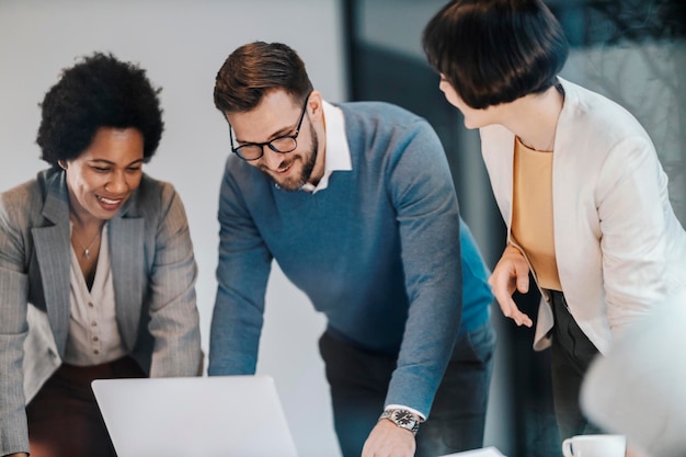 Foto gli uomini d'affari multiculturali sono in ufficio e guardano il laptop