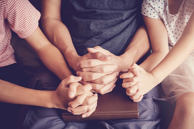 Photo multicultural children praying with their father at home