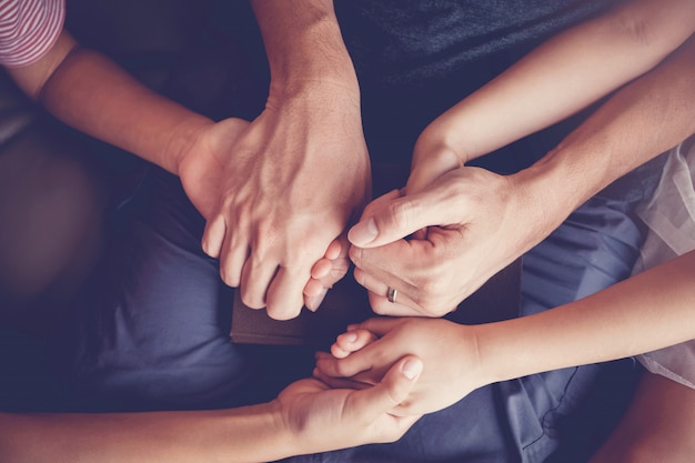 Multicultural children praying with their father at home