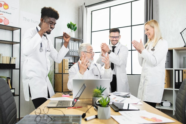 Multicultural doctors smiling and clapping during conference