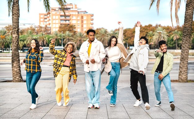 Multicultural friends walking at Barceloneta waterfront on funny moves
