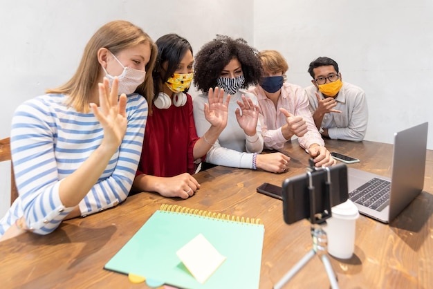 Gruppo multiculturale di millennial in videoconferenza sulle attuali problematiche sociali legate al team di studenti sull'epidemia di coronavirus impegnato in una chiamata online la nuova normale diversità e aggregazione