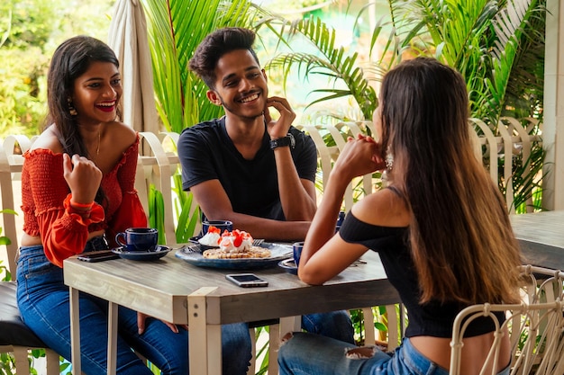 Multicultural group of people discussing by laptop in summer cafe surfing online freelancer freelance