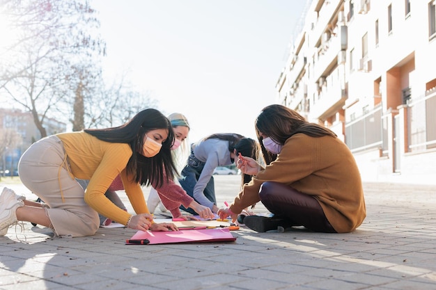 Gruppo multiculturale che prepara insieme la giornata internazionale delle donne del movimento femminista m