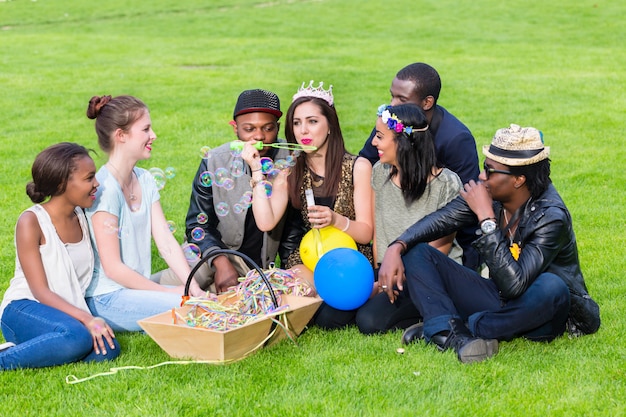 Multicultural group, sitting together on lawn