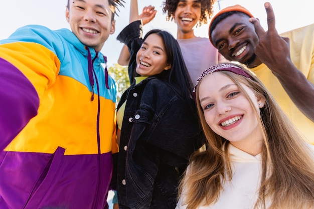 Foto gruppo multiculturale di giovani amici che si uniscono all'aperto e si divertono - ragazzi alla moda e alla moda che si riuniscono allo skate park urbano